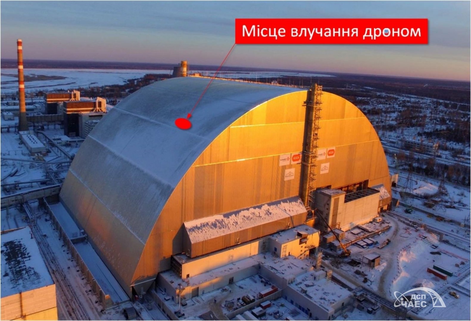 Arco metálico do Novo Confinamento Seguro sobre terreno nevado, com seta e círculo vermelhos da fonte indicando o ponto do impacto.