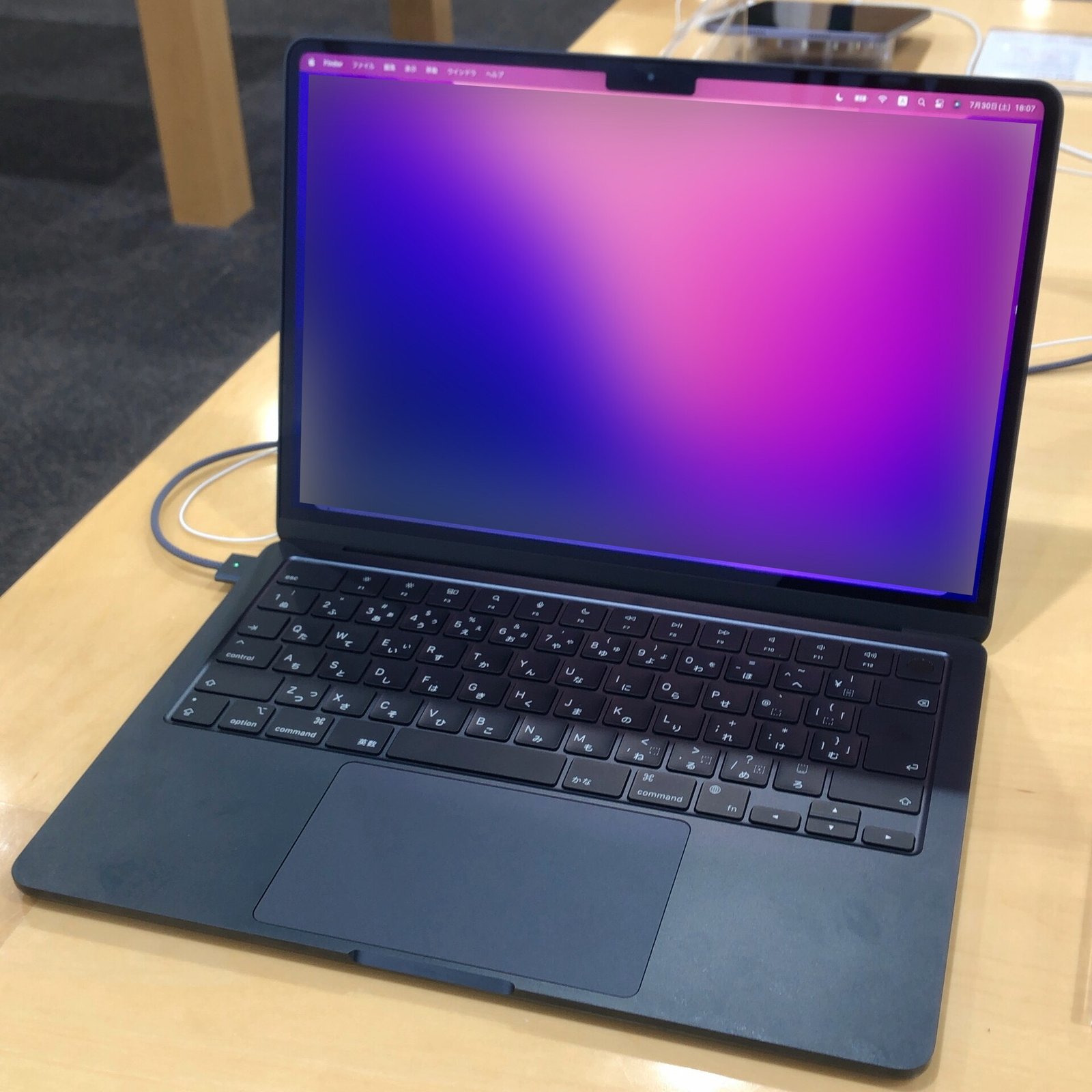 MacBook Air aberto em uma exposição comercial, com tela desfocada na versão da fotografia disponibilizada pelo Commons.