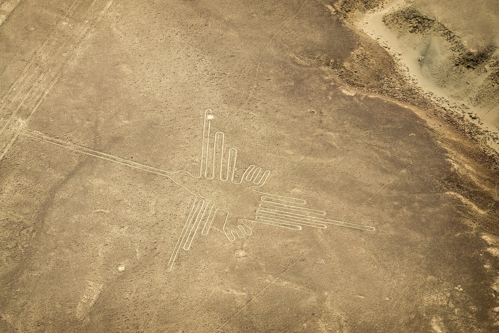 Vista aérea do geoglifo conhecido como beija-flor, traçado em linhas claras sobre a superfície do deserto.