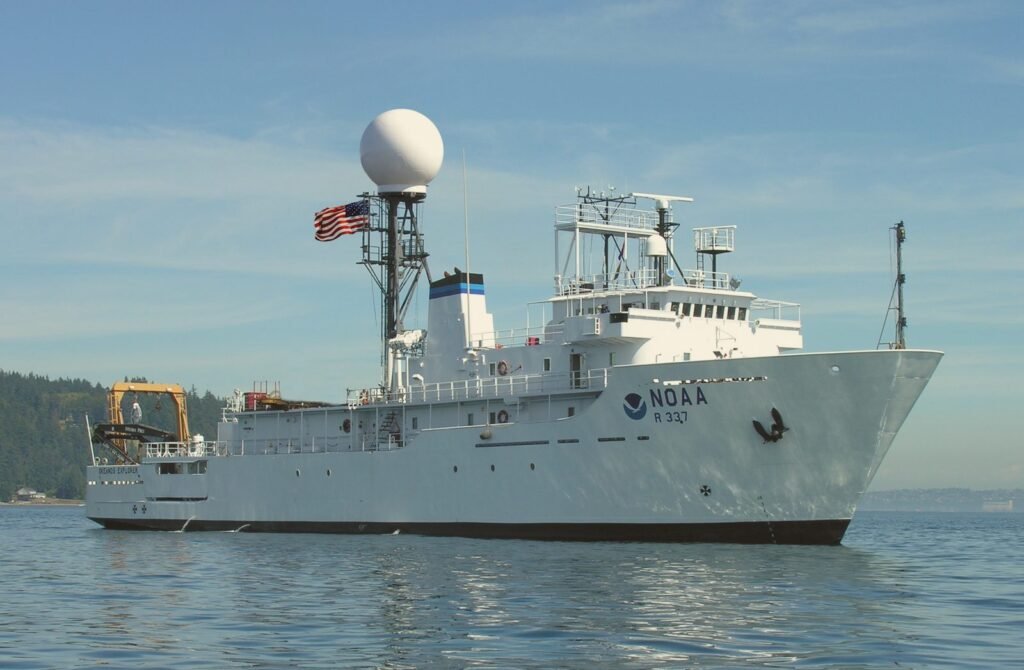 Navio de pesquisa branco navegando em mar calmo.