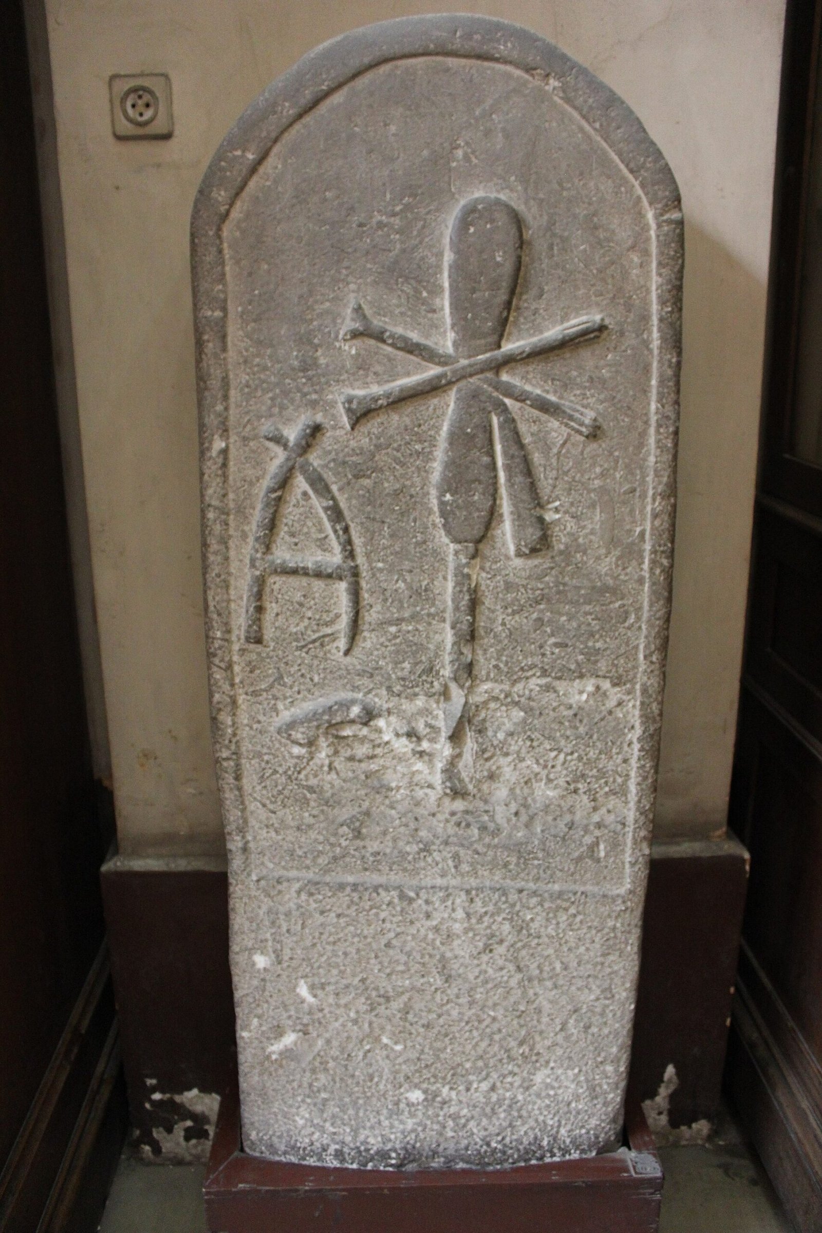 Estela de pedra com topo arredondado e sinais hieroglíficos em relevo, exposta no Museu Egípcio do Cairo.