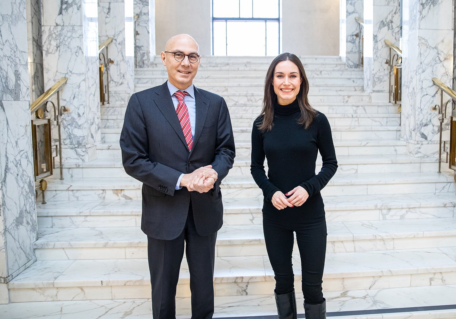 Volker Türk à esquerda e Sanna Marin à direita, em pé diante de uma escadaria em Helsinque.