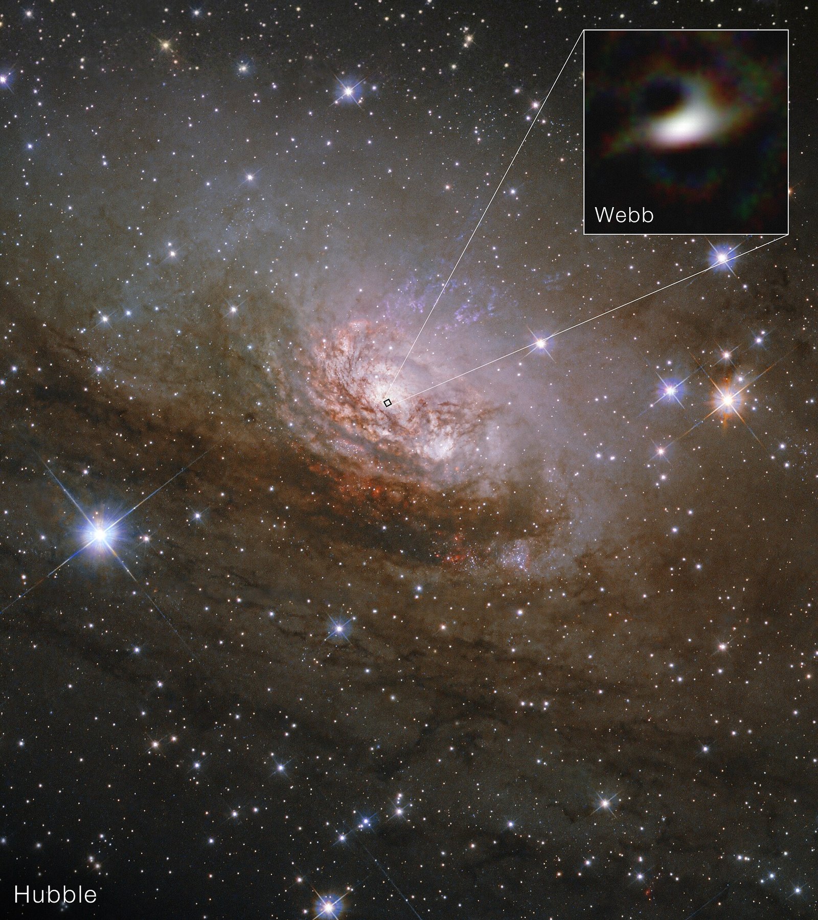 Uma galáxia espiral aparece entre muitas estrelas; um quadrado ampliado no alto mostra um oval luminoso sobre fundo escuro, conectado ao núcleo da galáxia.